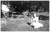Efter hvad jeg kan se er her igen et dobbeltbillede. Esther med to dukker på pinde eller var det slikkepinde? Bagved står Esther op ad en bil.1953 - 1954